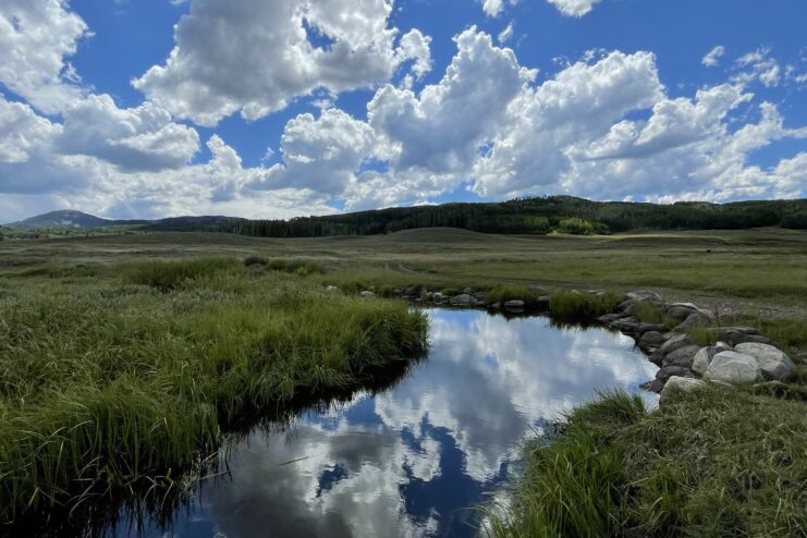 Slater Creek flowing through pasture land with clouds overhead